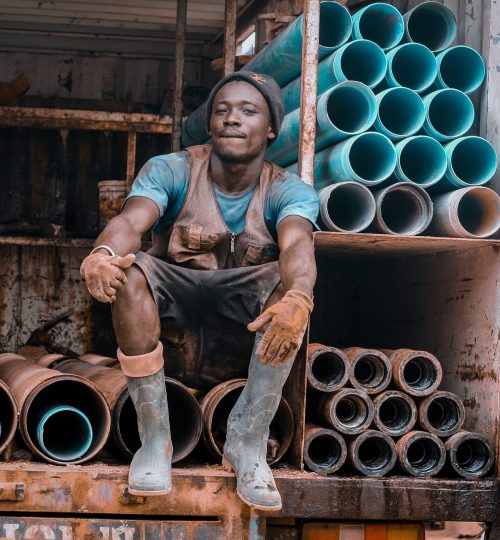 A worker sitting at a back of a car with drilling metals